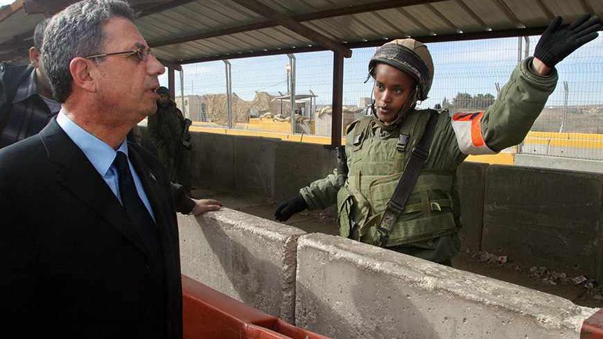 RAMALLAH, -:  An Israeli soldier talks to prominent Palestinian democracy and human rights activist Mustafa Barghuti, 51, at Kalandia checkpoint in the West Bank city of Ramallah 29 November 2004. Barghuti became the latest Palestinian who has decided to run in the January 09 presidential election to replace Yasser Arafat. Barghuti, secretary-general of the Palestinian national initiative, said that he wanted to make the fight against governmental corruption one of the main platforms of his campaign. AFP PH