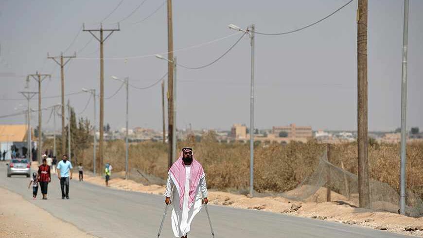 Syrian refugees walk along a road in the Zaatari refugee camp, near the Jordanian city of Mafraq July 18, 2013. The refugee camp holds roughly 115,000 Syrian refugees in Jordan about 12 km (eight miles) from the Syrian border. REUTERS/Mandel Ngan/Pool (JORDAN - Tags: POLITICS SOCIETY IMMIGRATION) - RTX11QJ0