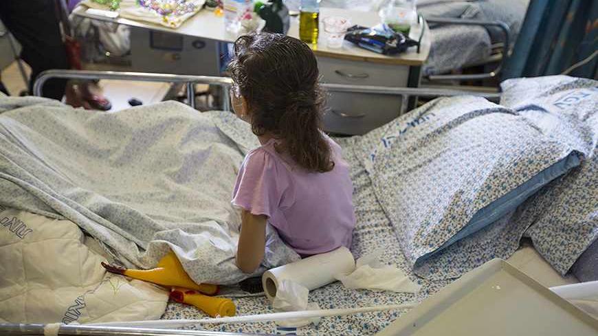 A wounded Syrian girl sits on a hospital bed at Ziv Medical Center in the northern Israeli town of Safed September 9, 2013. What started this year as a trickle is now a steady flow of Syrians, scores of civilians and fighters wounded in the civil war and being discreetly brought across the Golan frontline into Israel - a country with which Syria is formally still at war. Picture taken September 9, 2013. REUTERS/Baz Ratner (ISRAEL - Tags: POLITICS HEALTH) - RTX13JW4