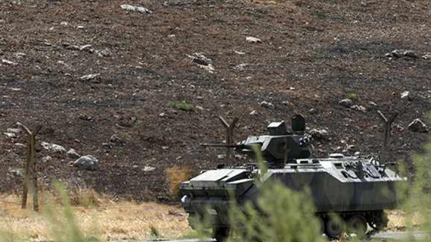 A Turkish military armoured vehicle patrols on the border line near Turkish Cilvegozu border gate, located opposite the Syrian commercial crossing point Bab al-Hawa in Reyhanli, Hatay province, September 17, 2013. REUTERS/Umit Bektas (TURKEY - Tags: POLITICS SOCIETY IMMIGRATION CONFLICT MILITARY) - RTX13OB0