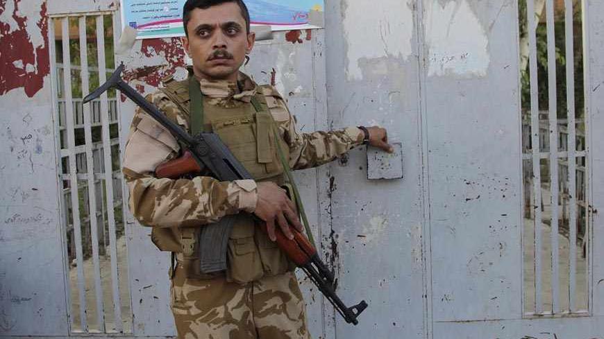 A Kurdish security forces member stands guard outside a polling station after its closing in Arbil, capital of the autonomous Kurdistan region, about 350 km (217 miles) north of Baghdad, September 21, 2013.  Iraqi Kurds voted on Saturday for a new parliament that analysts said was poised to lead the oil-producing region further down the road to greater autonomy from Baghdad. REUTERS/Azad Lashkari  (IRAQ - Tags: ELECTIONS POLITICS BUSINESS) - RTX13TNL