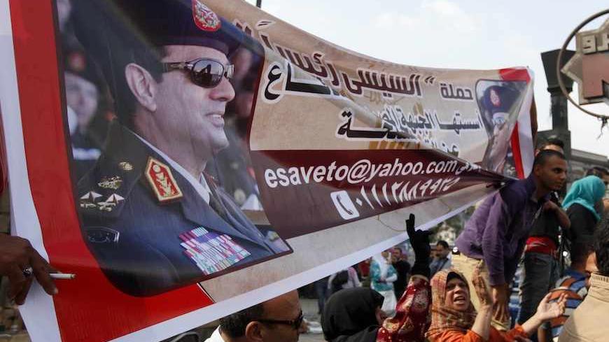 Supporters of the military hold a banner of Army chief General Abdel Fattah al-Sisi outside the Egyptian High Court in Cairo November 4, 2013. Ousted Egyptian president Mohamed Mursi struck a defiant tone on the first day of his trial on Monday, chanting 'Down with military rule', and calling himself the country's only 'legitimate' president. Mursi, an Islamist who was toppled by the army in July after mass protests against him, appeared angry and interrupted the session repeatedly, prompting a judge to adj