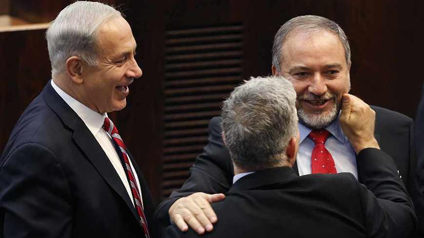 Israel's Prime Minister Benjamin Netanyahu (L) and Finance Minister Yair Lapid (back to camera) congratulate Israeli far-right leader Avigdor Lieberman after he was sworn in as Israel's Foreign Minister at the parliament in Jerusalem November 11, 2013. Lieberman was sworn in as foreign minister on Monday after his acquittal on corruption charges, a development that could further complicate peace talks with the Palestinians. REUTERS/Amir Cohen (JERUSALEM - Tags: POLITICS TPX IMAGES OF THE DAY) - RTX159MP
