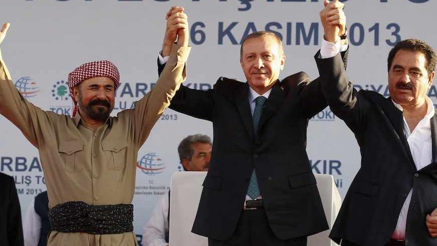 Turkey's Prime Minister Tayyip Erdogan, Kurdish poet and singer Sivan Perwer (L), who had fled Turkey in the 1970s, and Turkish singer Ibrahim Tatlises (R) greet people during a ceremony in Diyarbakir November 16, 2013. The president of Iraqi Kurdistan called on Turkey's Kurds to back a flagging peace process with Ankara on Saturday, making his first visit to southeastern Turkey in two decades in a show of support for Prime Minister Tayyip Erdogan. Masoud Barzani's trip to Diyarbakir, the main city in Turk