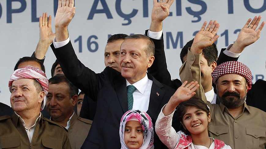 Turkey's Prime Minister Tayyip Erdogan, President of Iraqi Kurdistan Masoud Barzani (L) and Kurdish poet and singer Sivan Perwer (R), who had fled Turkey in the 1970s, greet people, as they are flanked by politicians and chidren during a ceremony in Diyarbakir November 16, 2013. The president of Iraqi Kurdistan called on Turkey's Kurds to back a flagging peace process with Ankara on Saturday, making his first visit to southeastern Turkey in two decades in a show of support for Prime Minister Tayyip Erdogan