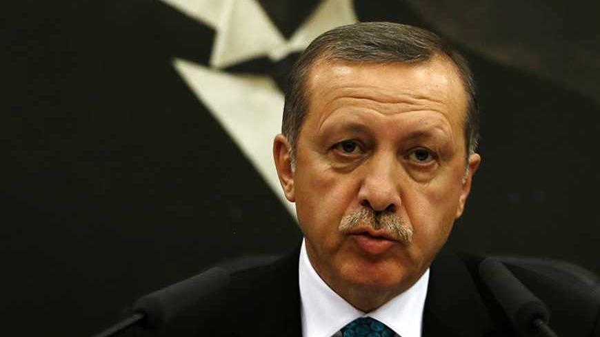 Turkish Prime Minister Tayyip Erdogan addresses the media as he sits in front of a portrait of Mustafa Kemal Ataturk, founder of secular Turkey, at Esenboga Airport in Ankara November 21, 2013. A feud between Erdogan and an influential Islamic cleric, Fethullah Gulen, has spilled into the open months ahead of elections, highlighting fractures in the religiously conservative support base underpinning his decade in power. REUTERS/Umit Bektas (TURKEY - Tags: POLITICS RELIGION) - RTX15NGN