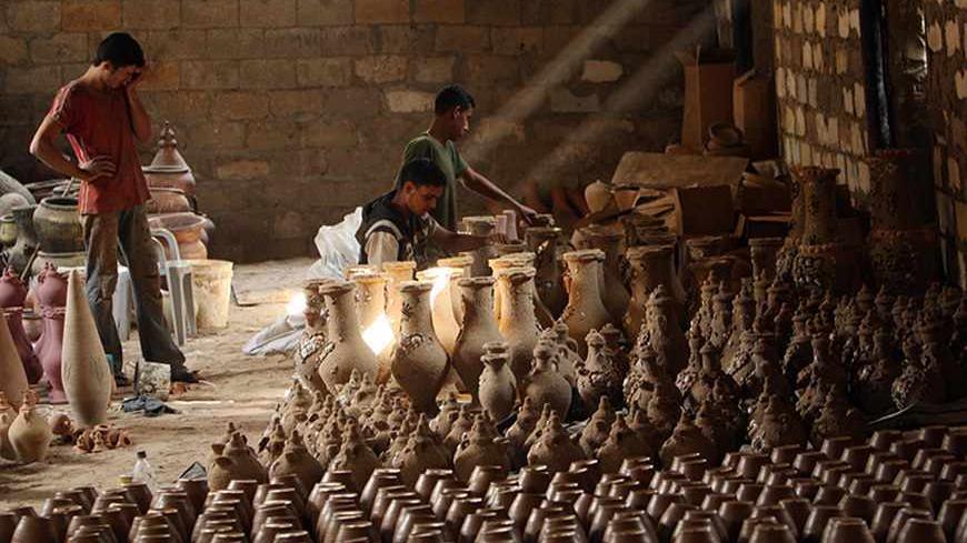 Palestinian workers make clay pots inside a pot factory in Gaza October 19, 2008. The making of clay pots is an ancient and traditional profession in the Gaza Strip. REUTERS/Suhaib Salem (GAZA) - RTX9PE0
