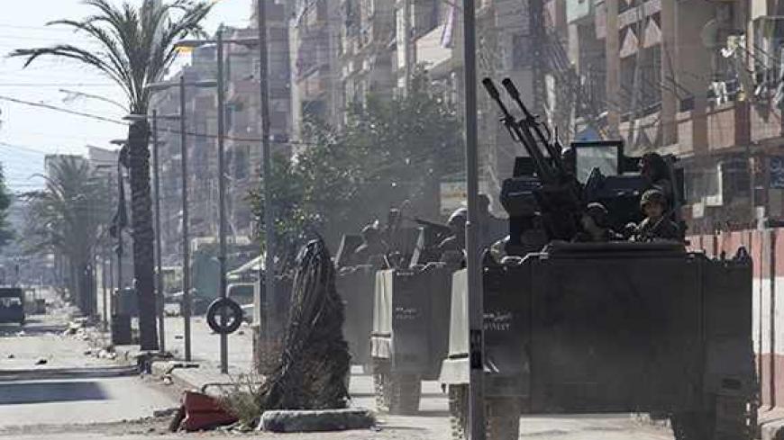 Lebanese army soldiers ride on their military vehicles after being deployed to tighten security following days of clashes between Sunni Muslims and Alawites in the northern port city of Tripoli October 28, 2013. Two people died in the northern city of Tripoli on Monday, security and medical sources said, in fighting between supporters and opponents of Syrian President Bashar al-Assad and the Lebanese army which has spilled over from the war next door.   REUTERS/Omar Ibrahim (LEBANON - Tags: POLITICS CIVIL U