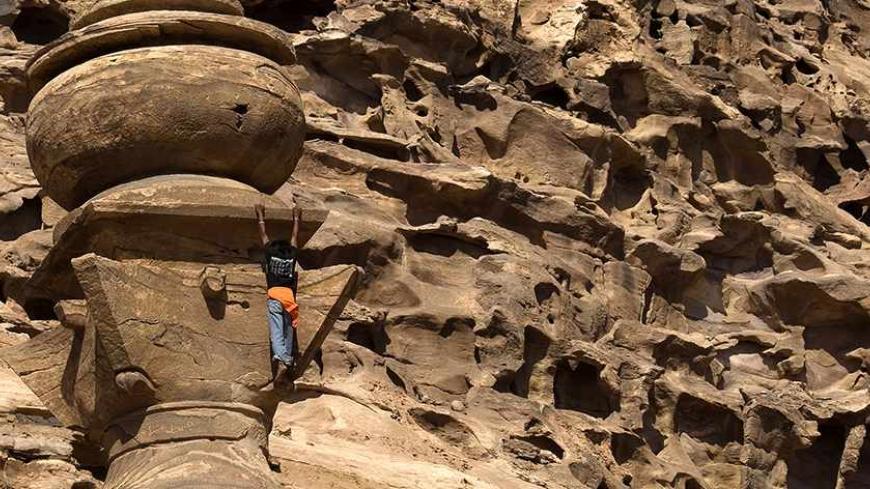 Salem Hammed, 23, a Bedouin guide, climbs to the top of ad Dayr (The Monastery) in the ancient city of Petra August 31, 2007. Ad Dayr has the largest facade (45 by 50 metres, or 130 by 164 ft) in Petra, Jordan. Petra was recently named among the modern-day seven wonders of the world chosen in a poll of 100 million online voters. Picture taken August 31, 2007.   REUTERS/Steve Crisp   (JORDAN) - RTR1TAY9