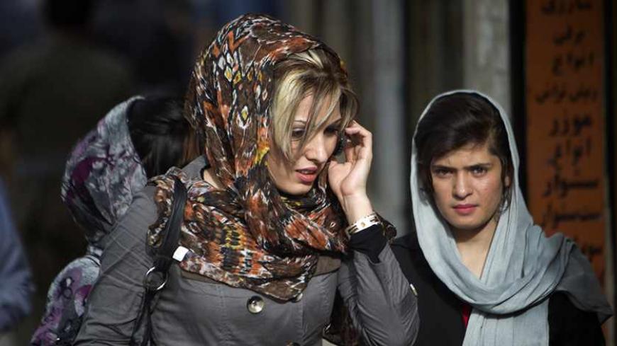 An Iranian-Kurd woman talks on her mobile phone as she walks at a bazaar while shopping in Marivan in Kurdistan province, 512 km (318 miles) west of Tehran, May 12, 2011. Iranian Shi'ite and Sunni Kurds live in harmony with each other in Marivan, although Sunni is the religion of the majority of the people. REUTERS/Morteza Nikoubazl (IRAN - Tags: SOCIETY RELIGION) - RTR2MC86