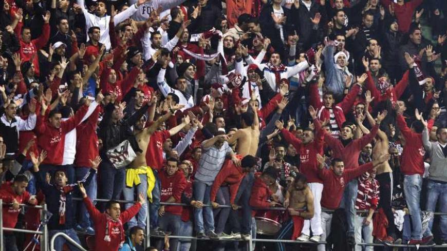 Fans of Bnei Sakhnin shout slogans during a match against Beitar Jerusalem as part of the Israeli Premier League, at Teddy Stadium in Jerusalem February 10, 2013. There was heightened security at Sunday's match following last week's arraignment of four fans in connection with racist incitement against the team's recruitment of Muslim players. REUTERS/Nir Elias (JERUSALEM - Tags: SPORT SOCCER POLITICS) - RTR3DLIL
