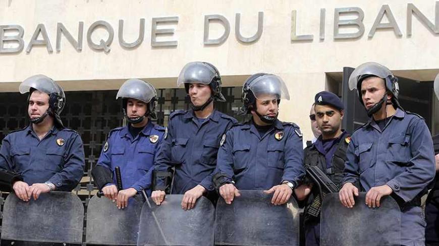 Lebanese riot police stand guard at the Lebanese Central Bank in Beirut February 25, 2013. An open-ended strike by teachers and civil servants entered its second week today for the government to approve the wage hike proposal. REUTERS/Mohamed Azakir (LEBANON - Tags: POLITICS CIVIL UNREST) - RTR3E9U4