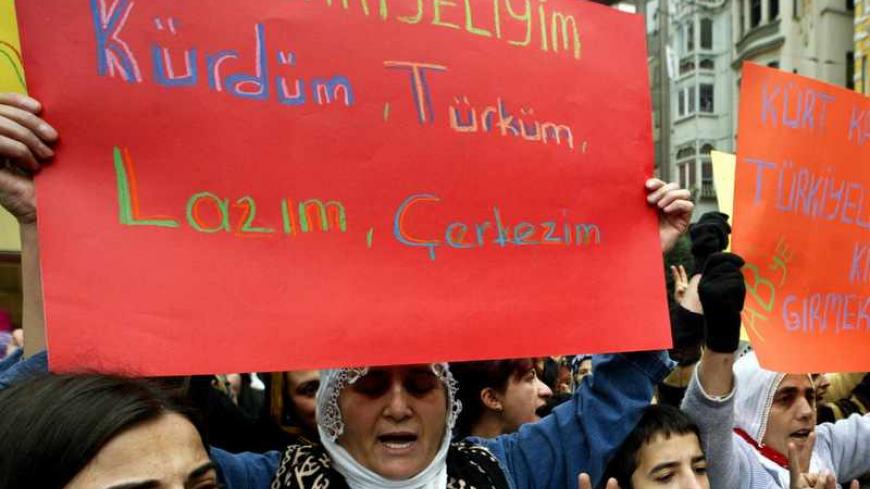 Demonstrators shout slogans as they hold up banners while staging a protest in central Istanbul December 11, 2004. Hundreds of protesters formed a human chain through the busy shopping street of Istiklal on Saturday to protest the recent killing of a 12-year-old boy and his father by security forces in Kiziltepe in the southeast Turkish province of Mardin which is now under investigation. Banner at left reads in Turkish "I am Turkish, Kurdish, Circassian and Laz from Turkey" and the banner at top right read