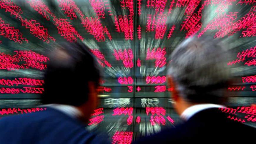 Japanese businessmen look closely at stock prices flashing outside a brokerage in Tokyo September 26, 2005. The Nikkei average rose 1.77 percent or 233.27 points to 13,392.63, its highest close since June 2001 after investors were encouraged by a survey showing growing confidence among big manufacturers and damage from Hurricane Rita in the United States was less-than-expected. REUTERS/Yuriko Nakao PP05090317 - RTRPE4R