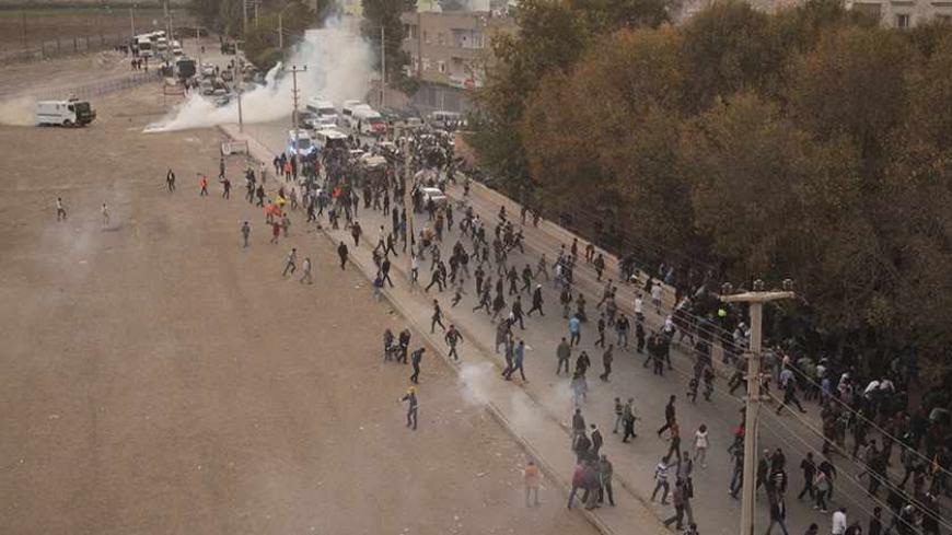 Riot police use tear gas to disperse pro-Kurdish demonstrators during a protest in the southeastern Turkish town of Nusaybin, on the Turkish-Syrian border, November 7, 2013. Thousands of Kurds protested on Thursday against Turkish plans to build a wall along the Syrian border, calling it a move to stop Kurdish communities strengthening cross-frontier ties as Syria splinters from civil war. Nusaybin is separated from the Syrian town of Qamishli by a strip of no-man's land and barbed wire fencing. REUTERS/Str