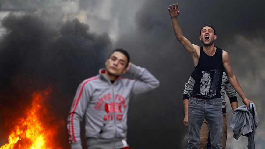 A supporter of the Muslim Brotherhood and ousted Egyptian President Mohamed Mursi shouts slogans in front of tear gas fired by riot police and army, during clashes at El-Talbyia near Giza square, south of Cairo, November 29, 2013. Mursi's supporters have staged frequent protests across Egypt, many of them after Friday prayers, since the army deposed him on July 3 in response to mass protests against his rule, and arrested most of the top leaders of his Muslim Brotherhood. REUTERS/Amr Abdallah Dalsh (EGYPT