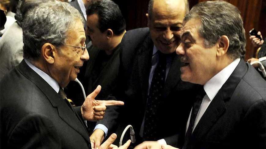 Amr Moussa (L), head of the assembly writing Egypt's new constitution, speaks with El-Sayed El-Badawi (R), the head of the Wafd party, before a vote at the Shura Council in Cairo December 1, 2013. The assembly writing Egypt's new constitution voted on Sunday against an article that requires parliamentary elections to be held before presidential elections, raising uncertainty over the country's political transition timetable. REUTERS/Stringer  (EGYPT - Tags: POLITICS) - RTX16036