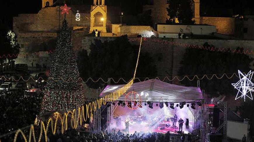 Musicians perform on stage in Manger Square, outside the Church of the Nativity, the site revered as the birthplace of Jesus, in the West Bank town of Bethlehem December 1, 2013. REUTERS/Ammar Awad (WEST BANK - Tags: RELIGION) - RTX1605A