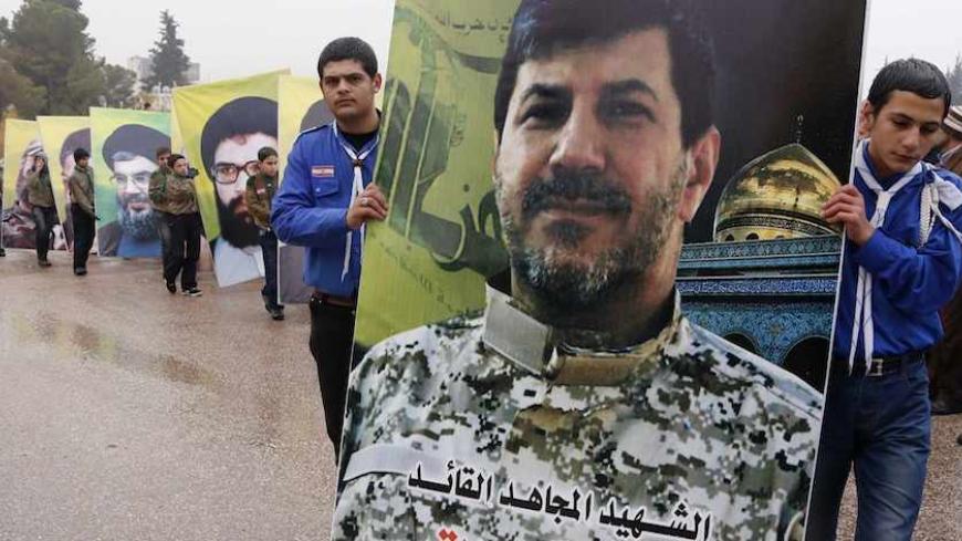 Lebanon's Hezbollah boy scouts carry a picture of Hezbollah commander Hassan al-Laqqis during his funeral in Baalbeck, in Lebanon's Bekaa valley December 4, 2013. Al-Laqqis, a Hezbollah commander who fought in Syria's civil war was shot dead outside his home in Lebanon on Wednesday in an attack which the militant Shi'ite group blamed on Israel. Israel denied any role in the killing of Hassan al-Laqqis, who was shot from close range by a silenced gun as he arrived home at around midnight in the Hadath distri