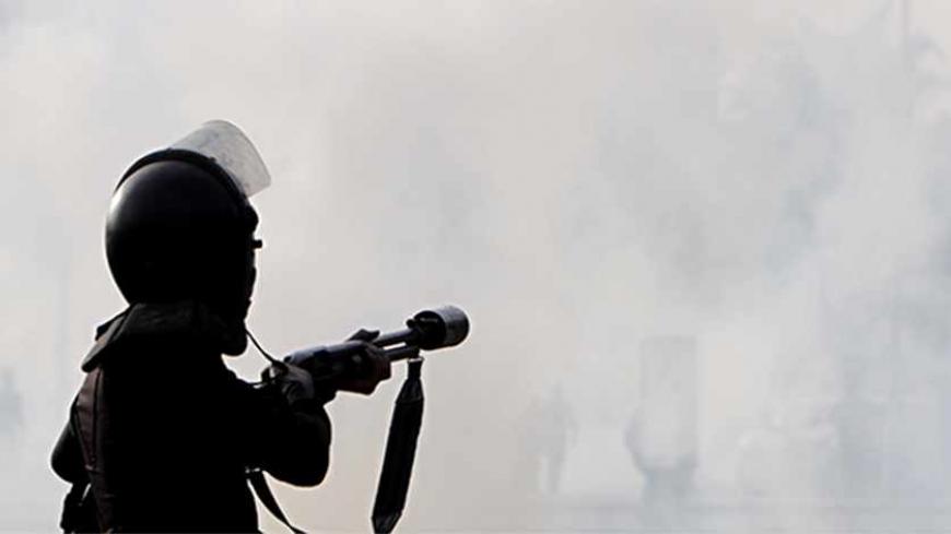 Riot police clash with Cairo University students, who are supporters of the Muslim Brotherhood and ousted Egyptian President Mohamed Mursi, in front of the main gate of the university in Cairo December 10, 2013. REUTERS/Mohamed Abd El Ghany  (EGYPT - Tags: POLITICS CIVIL UNREST) - RTX16CGZ