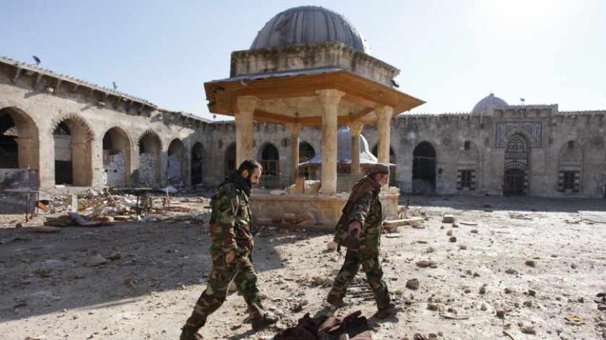 Free Syrian Army fighters walk with their weapons in the Umayyad mosque of Old Aleppo, December 15, 2013. REUTERS/Molhem Barakat (SYRIA - Tags: POLITICS CIVIL UNREST CONFLICT RELIGION) - RTX16JWX