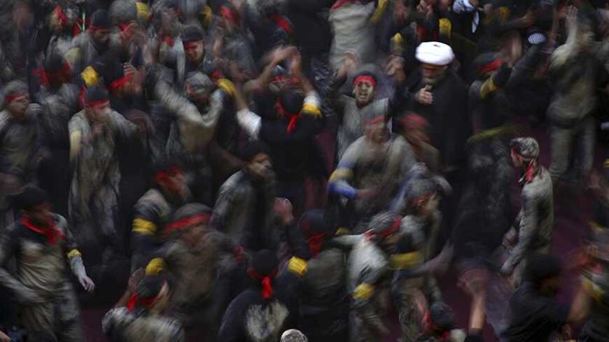 Shi'ite pilgrims beat their chests in a ceremony to mark the religious ritual of Arbain in Kerbala, about 80 km (50 miles) southwest of Baghdad, December 23, 2013. Hundreds of thousands of Shi'ite pilgrims have been pouring into the southern Iraqi city of Kerbala to mark Arbain, a major event in the Shi'ite Muslim calendar. Pilgrims have been arriving from Iran, Pakistan and Gulf Arab countries to observe the end of the 40-day mourning period following Ashura, the religious ritual that commemorates the deat