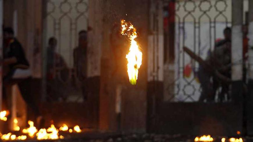 A Molotov cocktail is seen mid-air during clashes between riot police and students of Al-Azhar University, who support the Muslim Brotherhood and ousted Egyptian President Mohamed Mursi, outside the university's campus in Cairo's Nasr City district December 27, 2013. Muslim Brotherhood supporters and police clashed across Egypt on Friday, leaving at least three dead in protests after the army-backed government declared the group a terrorist organisation. REUTERS/Amr Abdallah Dalsh (EGYPT - Tags: POLITICS