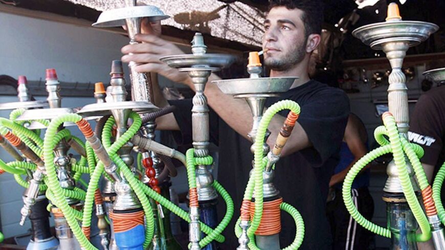 A Palestinian vendor prepares water pipes at his shop on the beach of Khan Younis in the southern Gaza Strip May 31, 2009. Sunday marks World No Tobacco Day. REUTERS/Ibraheem Abu Mustafa (GAZA ANNIVERSARY HEALTH) - RTR2443D