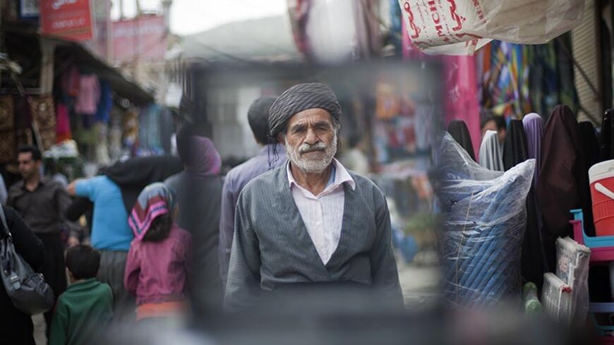 An Iranian Sunni Kurd walks at a bazaar while shopping in Marivan in Kurdistan province, 512 km (318 miles) west of Tehran, May 12, 2011. Iranian Shi'ite and Sunni Kurds live in harmony with each other in Marivan, although Sunni is the religion of the majority of the people. REUTERS/Morteza Nikoubazl (IRAN - Tags: SOCIETY RELIGION IMAGES OF THE DAY) - RTR2MC6O