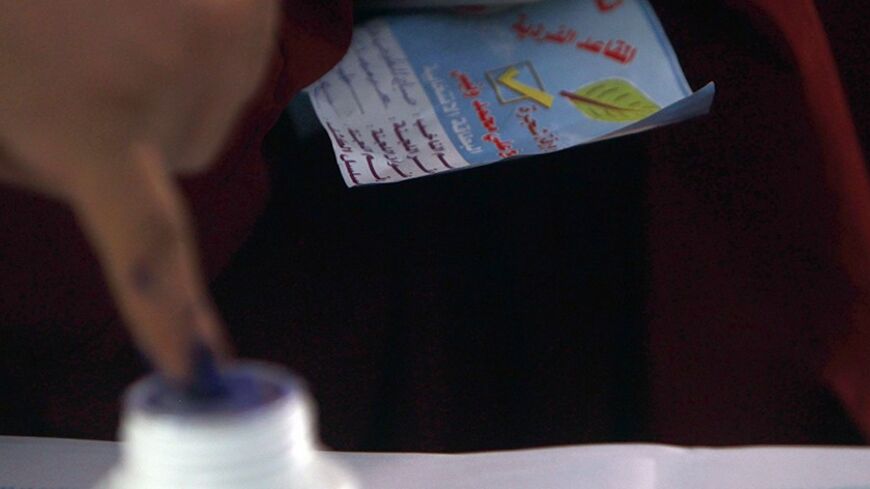 A man dips his finger in ink, as he holds a flyer from the Salafi political party Al-Nour, after casting his vote at a polling station in Toukh, El-Kalubia governorate about 25 km (16 miles) northeast of Cairo January 3, 2012. Egyptians voted in the third round of a parliamentary election on Tuesday that has so far handed Islamists the biggest share of seats in an assembly that will be central in the planned transition from army rule. REUTERS/Amr Abdallah Dalsh  (EGYPT - Tags: POLITICS ELECTIONS) - RTR2VUMG