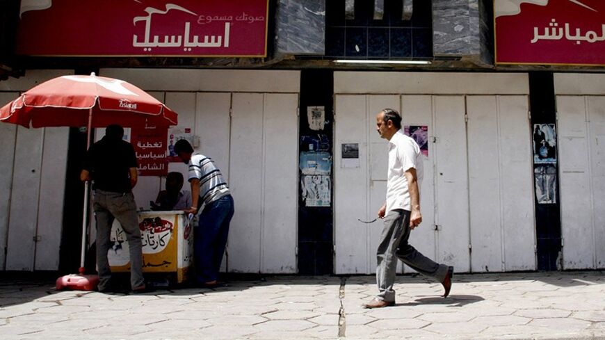 An independent Iraqi vendor sells Asiacell simcards for cell phones in front of the Asiacell company headquarters in Mosul, 390 km (240 miles) north of Baghdad, May 9, 2012. Mobile phone operator Asiacell has closed its offices in the Iraqi city of Mosul, an al Qaeda stronghold, after attacks and threats by militants, security officials and employees said this week. Picture taken May 9, 2012.  REUTERS/Khalid al-Mousuly (IRAQ - Tags: CONFLICT BUSINESS TELECOMS) - RTR31V6B