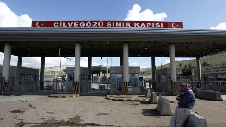 A man waits in front of the closed Cilvegozu border gate near the town of Reyhanli on the Turkish-Syrian border in Hatay province February 12, 2013. A deadly minibus blast on Turkey's border with Syria was meant to target a Syrian National Council opposition delegation, the group said on Tuesday, but the Turkish authorities said it was too early to apportion blame. The minibus, bearing Syrian number plates, exploded at a crossing on the border near the Turkish town of Reyhanli on Monday, killing 14 people a