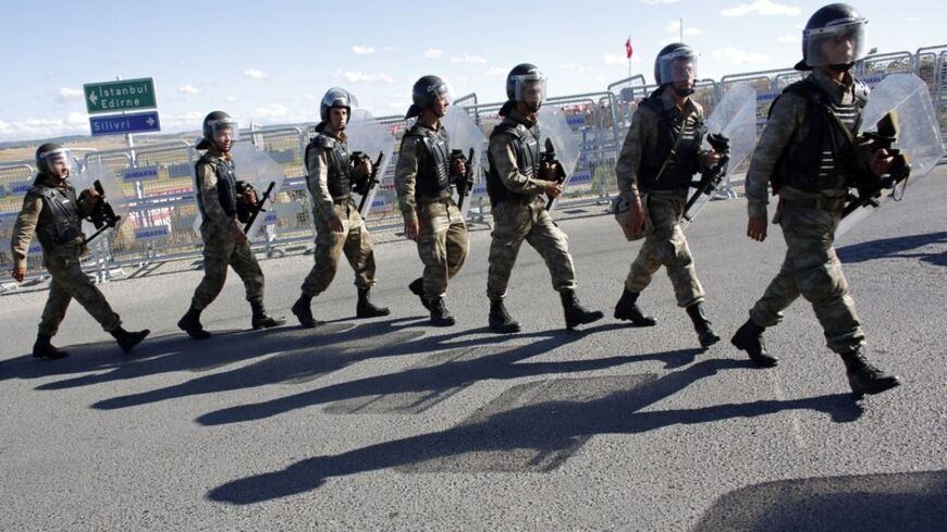 Turkish soldiers walk single file outside a courthouse in Silivri, where a hearing on people charged with attempting to overthrow Prime Minister Tayyip Erdogan's Islamist-rooted government is due to take place, August 5, 2013. A Turkish court on Monday began sentencing nearly 300 defendants accused of plotting to overthrow the government, handing prison sentences of up to 20 years to some and acquitting 21 others. The court was announcing the verdicts individually. Verdicts on high-profile defendants includ