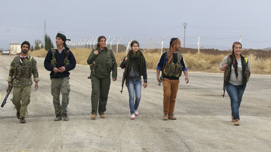 Members of the Kurdish People's Protection Units (YPG) walk together in Al-Rmelan, Qamshli province November 11, 2013. With a string of military gains across northeastern Syria, a Kurdish militia is solidifying a geographic and political presence in the war-torn country, posing a dilemma for regional powers. Long oppressed under Syrian President Bashar al-Assad and his father before him, Kurds view the civil war as an opportunity to gain the kind of autonomy enjoyed by their ethnic kin in neighbouring Iraq.
