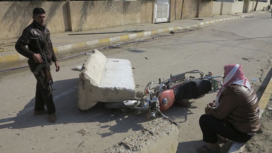 A man stands guard near the home of prominent Sunni Muslim lawmaker Ahmed al-Alwani after clashes with Iraqi security forces in the centre of Ramadi, December 28, 2013. Iraqi security forces arrested Alwani, a supporter of anti-government protests, in a raid on his home in the western province of Anbar, sparking clashes in which at least five people were killed, police sources said. They said those killed in the fighting included three of Alwani's bodyguards, his sister and his brother. REUTERS/Ali al-Mashh