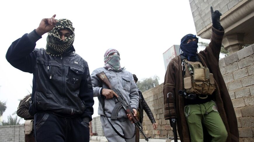 Gunmen fighters walk in the streets of the city of Falluja, 50 km (31 miles) west of Baghdad January 3, 2014. Sunni Muslim tribesmen backed by Iraqi troops fought al Qaeda-linked militants for control of Iraq's western province of Anbar on Friday in a critical test of strength for the Shi'ite-led government of Prime Minister Nuri al-Maliki. Those fears were stirred anew on Thursday when tribesmen, angry at the central government in Baghdad and what they perceive as Sunni marginalisation in politics, clashed