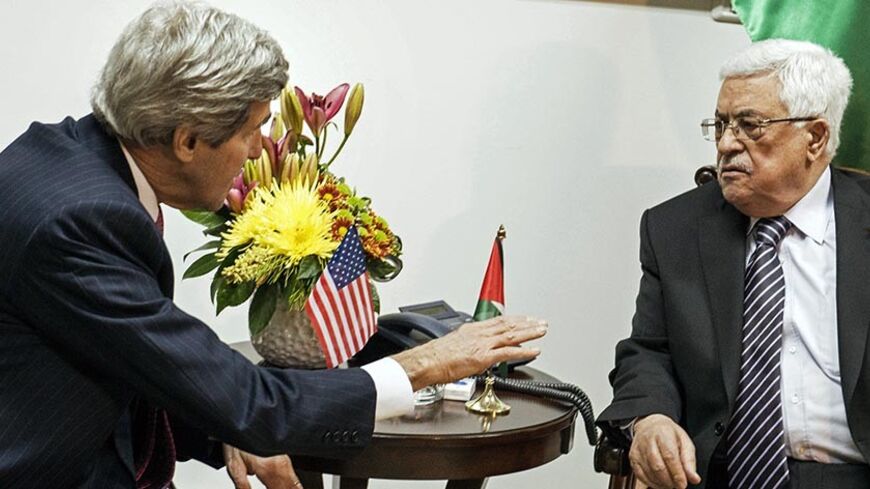U.S. Secretary of State John Kerry (L) and Palestinian President Mahmoud Abbas talk at a meeting at the presidential compound in the West Bank city of Ramallah January 4, 2014. REUTERS/Brendan Smialowski/Pool (WESTBANK) - RTX171OW