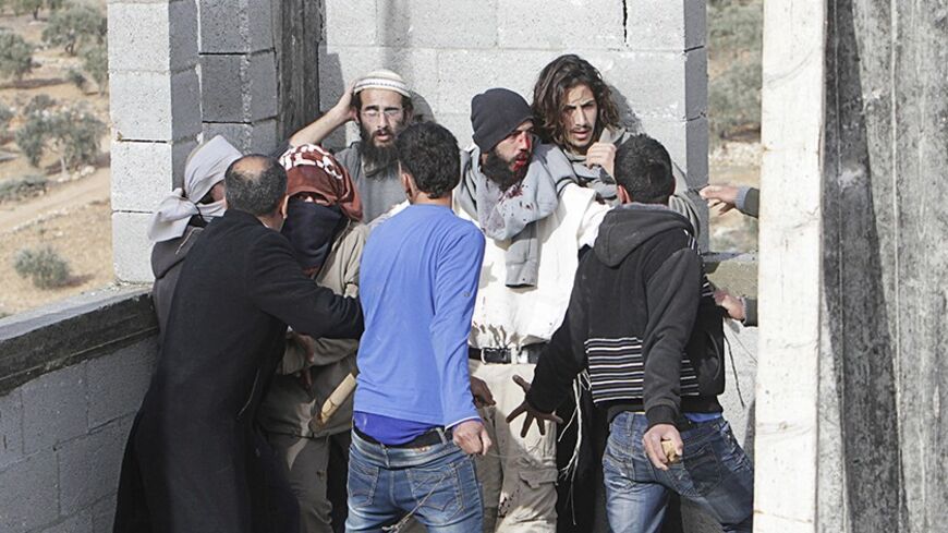 Palestinian villagers stand in front of Jewish settlers after they were detained in the West Bank village of Qusra near Nablus January 7, 2014. Palestinian villagers on Tuesday detained and beat up a group of Israeli settlers before freeing them, accusing the group of having thrown rocks at farmers tending their fields in the occupied West Bank. The incident added to simmering tensions between Israeli settlers and Palestinian villagers in the West Bank with the United States struggling to usher forward Isra