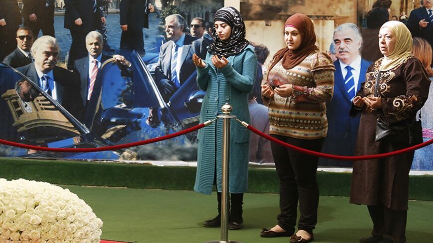 Women pray at the site of the grave of assassinated former Lebanese Prime Minister Rafik al-Hariri and his bodyguards in downtown Beirut January 15, 2014. Nine years after the assassination of Hariri, the trial of four men accused of his killing opens on Thursday. But the defendants are on the run, bombers are back on Beirut streets and a new era of justice which the trial was meant to introduce to Lebanon remains elusive. Hariri and 21 other people were killed on the Beirut seafront in February 2005, the d