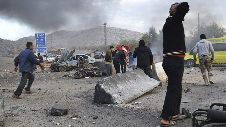 Men react as others rush at the site of a car bomb attack at the Bab al-Hawa border crossing between Syria and Turkey, in Idlib January 20, 2014. Two car bombs hit a rebel-held border post in the northwest Syrian province of Idlib on Monday, opposition activists and fighters said, killing at least 10 people and closing the frontier. The Bab al-Hawa crossing is held by a rebel alliance called the Islamic Front, which have been fighting with the al Qaeda-linked Islamic State in Iraq and the Levant (ISIL), a s