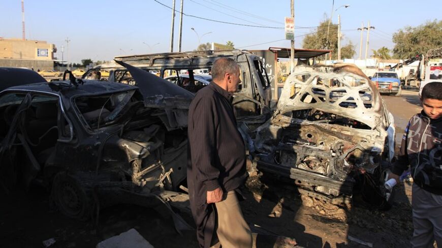 People look at the site of a car bomb attack in Abu Dsheer district in southern Baghdad January 20, 2014. Seven bomb explosions killed 26 people and wounded 67 in the Iraqi capital on Monday, police and medics said, as security forces battled Sunni Muslim militants around the western cities of Falluja and Ramadi. The bloodiest attack occurred in the mainly Shi'ite Muslim Abu Dsheer district in southern Baghdad, where a car bomb near a crowded market killed seven people and wounded 18.  REUTERS/Ahmed Saad (I
