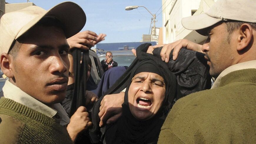 A woman mourns during the funeral of five Egyptian policemen who were killed when masked gunmen on motorbikes opened fire on a checkpoint in the province of Beni Suef, 100 km (62 miles) south of Cairo, January 23, 2014. REUTERS/Al Youm Al Saabi Newspaper (EGYPT - Tags: POLITICS CIVIL UNREST) EGYPT OUT. NO COMMERCIAL OR EDITORIAL SALES IN EGYPT - RTX17RGB