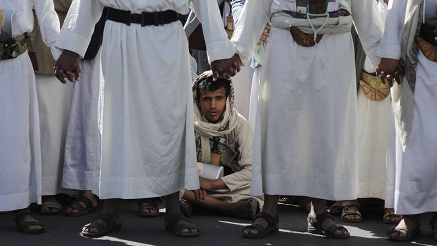 A mourner sits during the funeral of assassinated Shi'ite leader Ahmad Sharafeddin in Sanaa January 27, 2014. Unknown assailants shot and killed Sharafeddin on January 21 while he was on his way to attend reconciliation talks in the Yemeni capital, officials at the talks said. REUTERS/Khaled Abdullah (YEMEN - Tags: POLITICS CIVIL UNREST RELIGION OBITUARY) - RTX17WSB