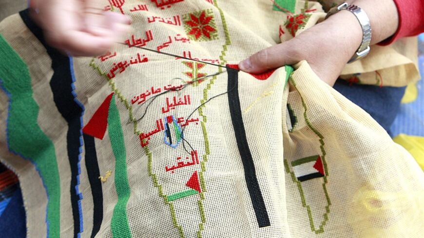 A Palestinian woman embroiders a map of Palestine to mark the 61st anniversary of Nakba at the Burj al-Barajneh refugee camp in Beirut May 15, 2009. Palestinians mark Nakba as a day of mourning for the establishment of Israel in 1948 after which an Arab-Israeli war brought the displacement of hundreds of thousands of Palestinians. REUTERS/Jamal Saidi (LEBANON ANNIVERSARY POLITICS) - RTXH51I