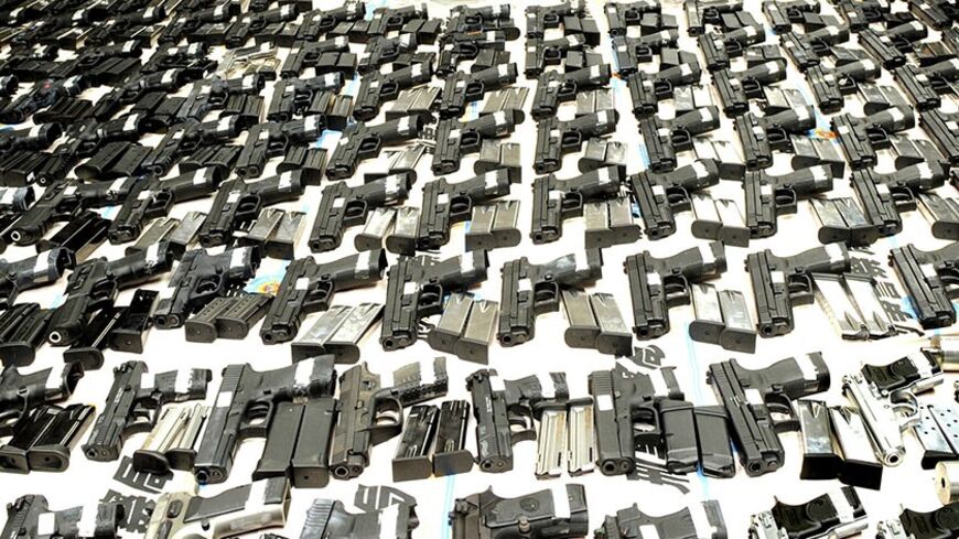 Police officers display seized firearms and ammunition for the media after a smuggling bust in Kaohsiung September 26, 2009. A haul of 181 guns and 22,685 rounds of ammunition were displayed for the media on Saturday as six suspects were arrested in what may be the largest arms smuggling bust ever in Taiwan, the Criminal Investigation Bureau (CIB) said. CIB officials said the seized weapons are standard models manufactured in Italy, Germany, Israel and the U.S. Picture taken September 26, 2009. REUTERS/St
