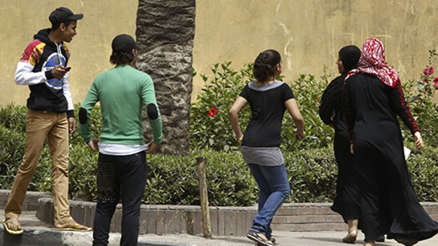 Youth try to harass women on a street in Cairo April 8, 2013. Egypt's National Council for Women (NCW) has proposed a new law against sexual harassment containing a minimum sentence of one-year imprisonment for first-time offenders, local media reported.  Picture taken April 8, 2013. REUTERS/Amr Abdallah Dalsh (EGYPT - Tags: POLITICS) - RTXYEPA