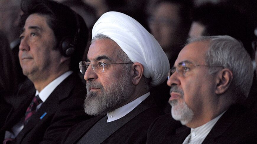 Iranian President Hassan Rouhani (C) sits next to Japanese Prime Minister Shinzo Abe (L) and Iranian Foreign Minister Mohammad Javad Zarif (R) during the World Economic Forum in Davos on January 22, 2014. Iran's President Hassan Rouhani takes centre stage at the Davos World Economic Forum Thursday, as he seeks to drum up investment for his sanctions-hit economy amid thawing relations with the West. AFP PHOTO ERIC PIERMONT        (Photo credit should read ERIC PIERMONT/AFP/Getty Images)