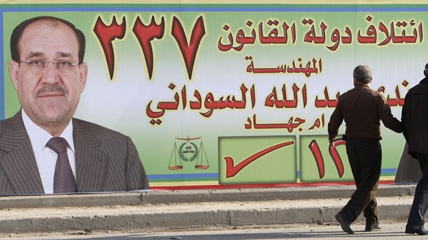 Residents walk past an election poster promoting Nada al-Sudani (R) and Prime Minister Nuri al-Maliki's State of Law coalition, in Baghdad February 12, 2010. Nada al-Sudani will be running as a candidate of the State of Law party during the March 7 parliamentary poll. REUTERS/Thaier al-Sudani (IRAQ - Tags: POLITICS ELECTIONS) - RTR2A4ZB