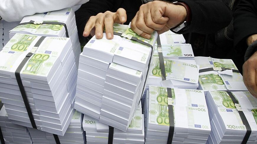 Supporters of Turkey's main opposition Republican People's Party (CHP) put a stack of fake bills on display during a protest against Turkey's ruling Ak Party (AKP) and Prime Minister Tayyip Erdogan in Istanbul February 26, 2014. The protest came after Erdogan accused political enemies of faking a recording of a phone conversation suggesting he had warned his son to hide large sums of money as the graft inquiry erupted. REUTERS/Osman Orsal (TURKEY - Tags: POLITICS CIVIL UNREST) - RTR3FQOY