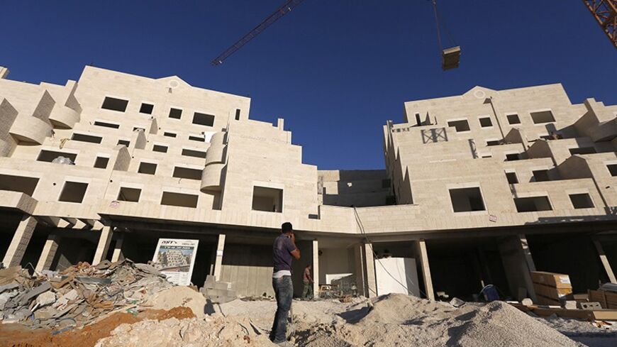 Palestinian labourers work on a construction site in Pisgat Zeev, an urban settlement in an area Israel annexed to Jerusalem after capturing it in the 1967 Middle East war, July 28, 2013. Prime Minister Benjamin Netanyahu on Sunday urged divided rightists in his cabinet to approve the release of 104 Arab prisoners in order to restart peace talk with the Palestinians. The prisoner release would allow Netanyahu to sidestep other Palestinian demands, such as a halt to Jewish settlement expansion. REUTERS/Baz R